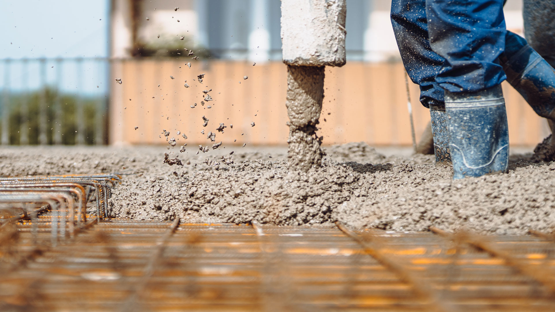 A person is pouring cement into the ground.